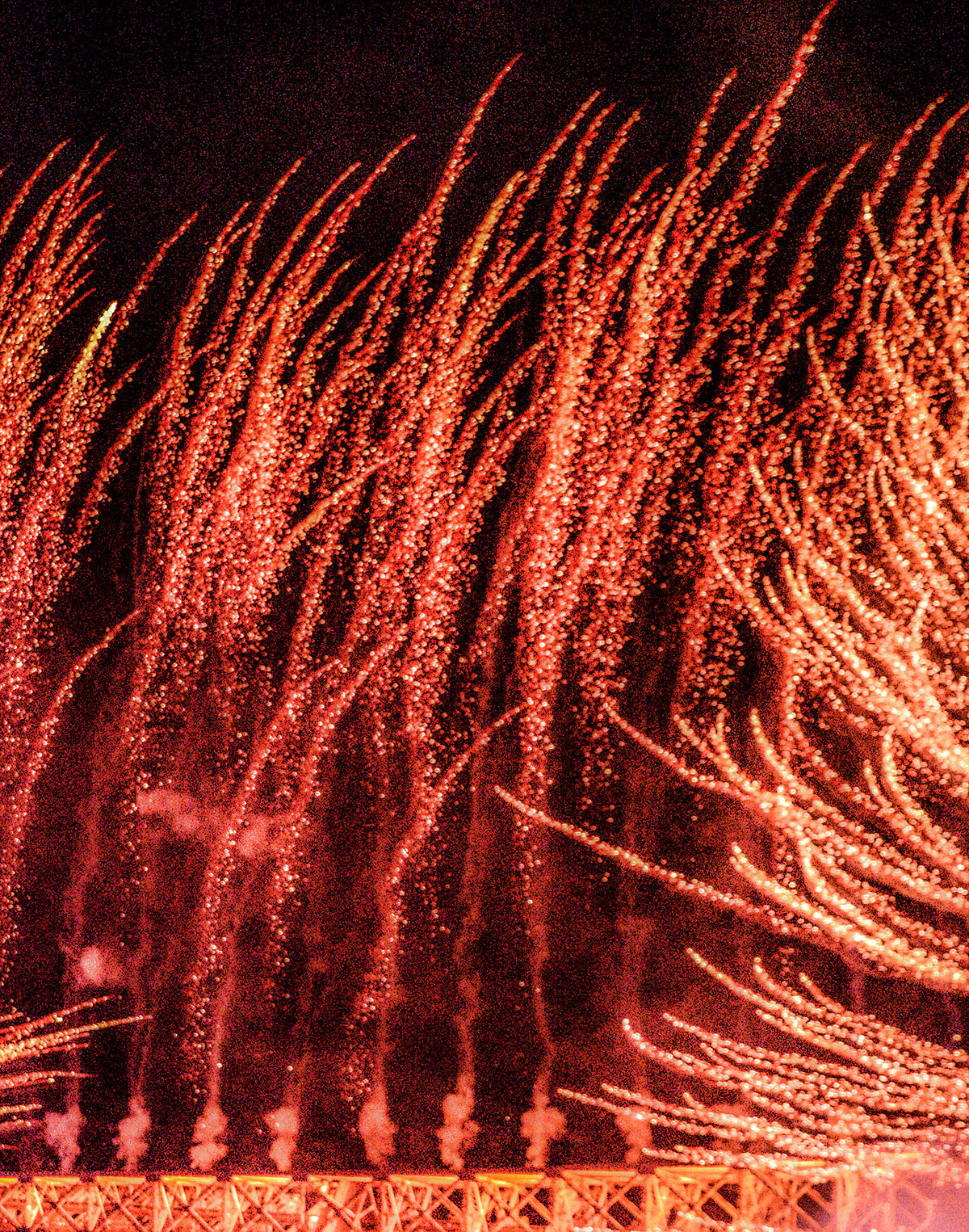Fireworks shooting from the Eiffel Tower on Bastille Day, cropped so they look like wheat growing from a steel earth