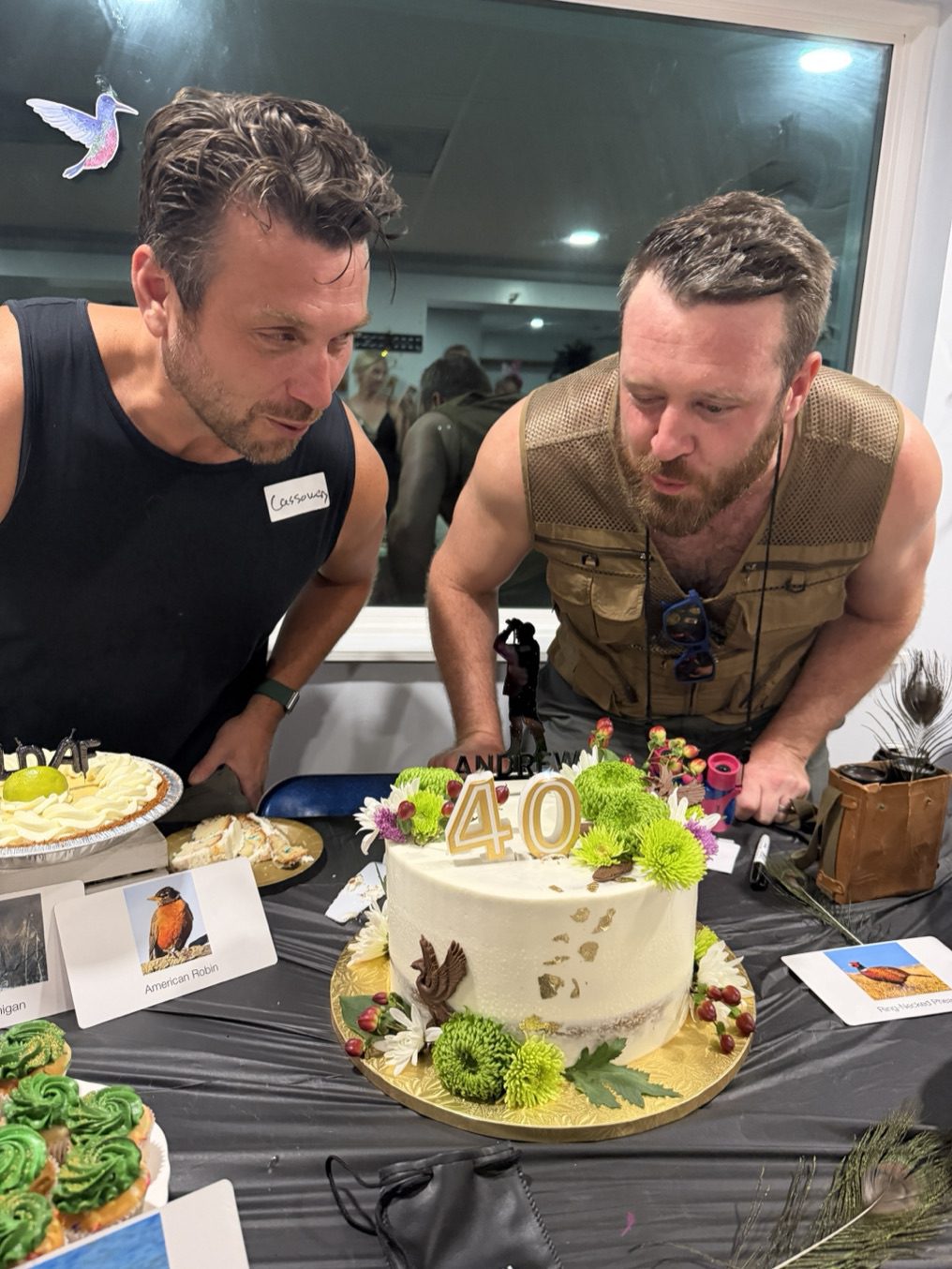 Joe leans over a birthday cake at a bird-themed party